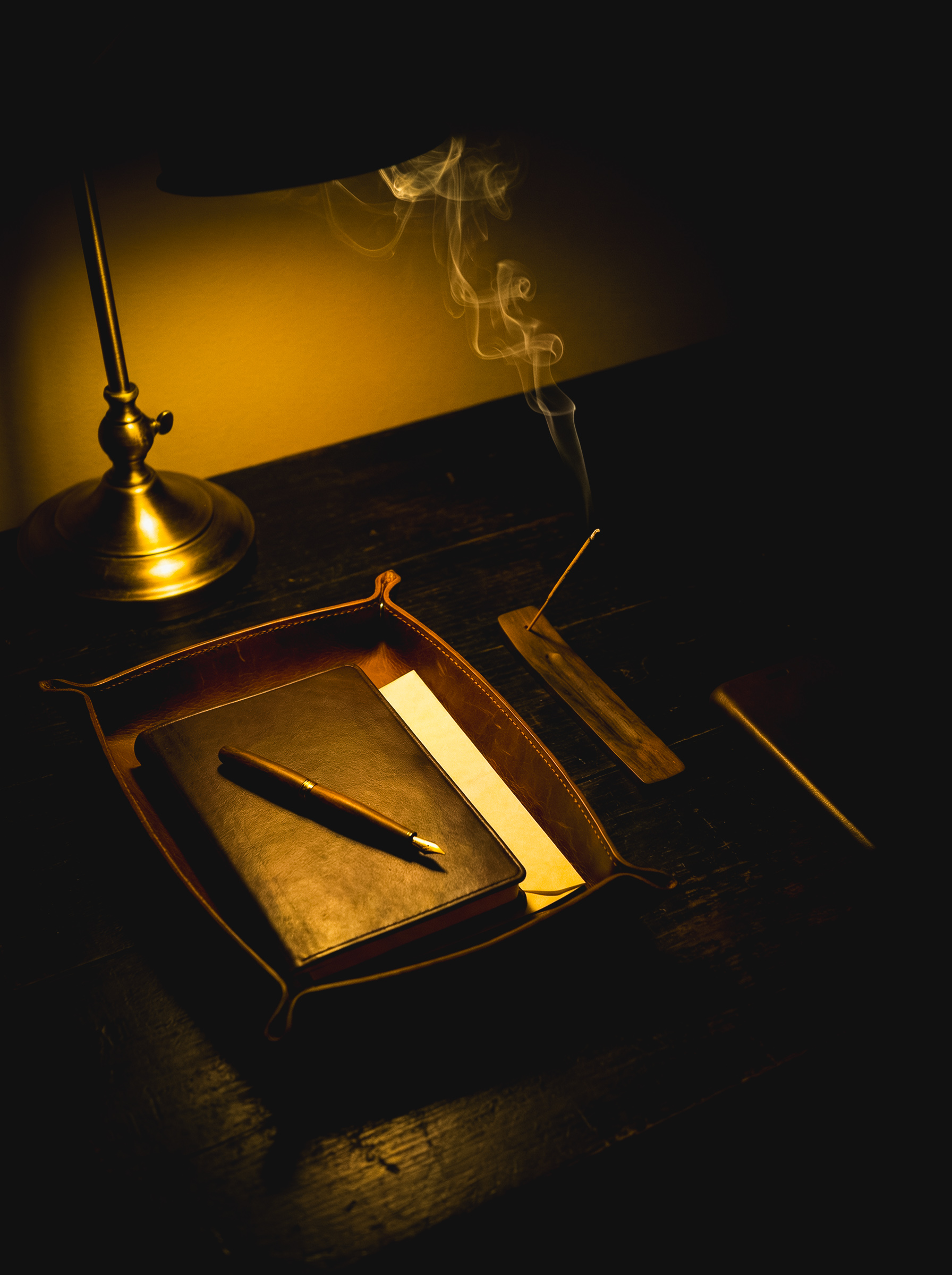 The Study — leather desk tray, diary and incense in lamplight